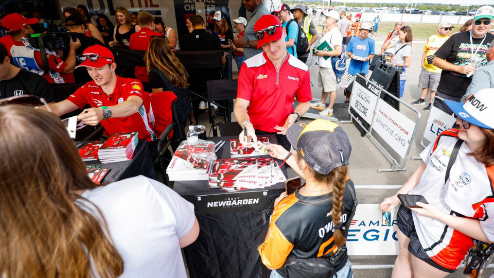 Josef Newgarden and Calum Ilot sign autographs for fans