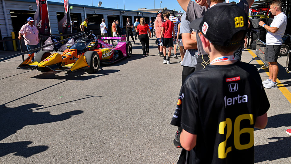 A child watches a car get rolled out in the garages